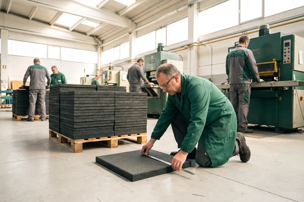 Rubber safety tile thickness being checked