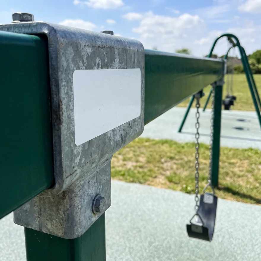 A blank white part label fixed to a galvanized swing hanger housing