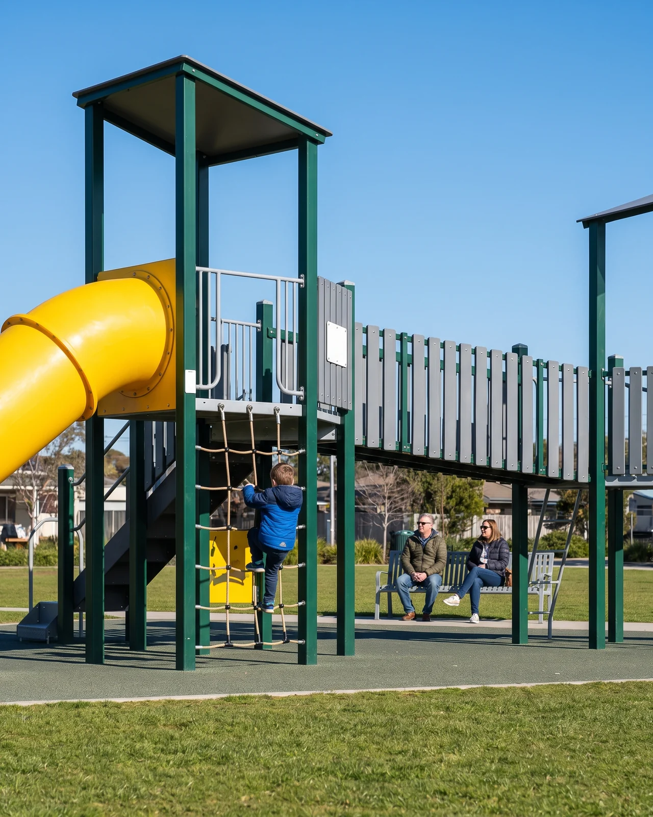 Commercial multi-deck outdoor play structure in a public park in morning sun