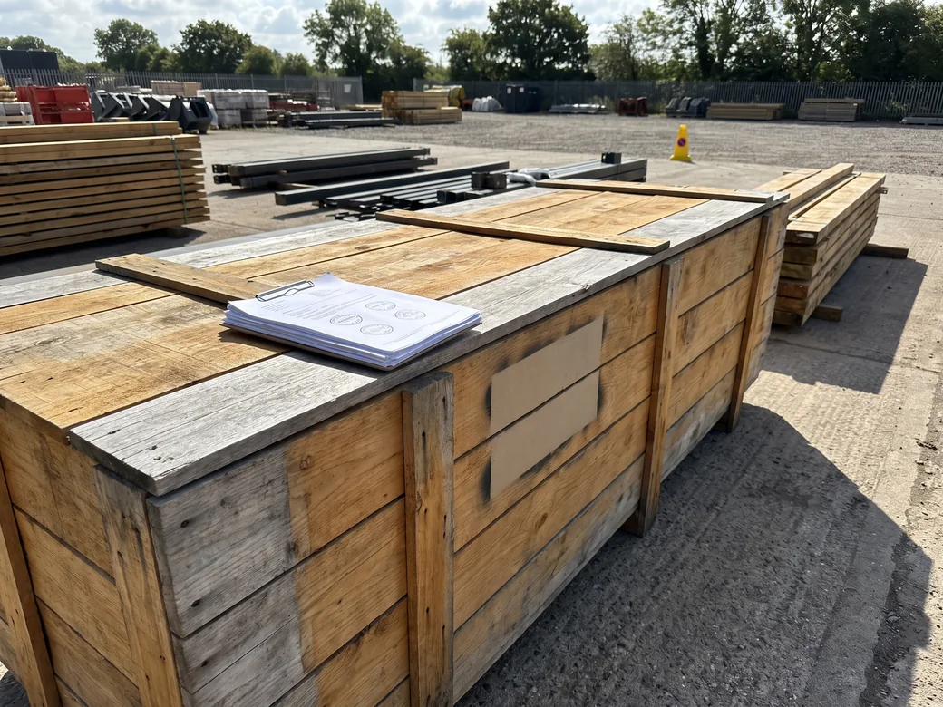 A stack of stamped export documents for a timber shipment, the fumigation and phytosanitary certificates on top, resting on a timber export crate