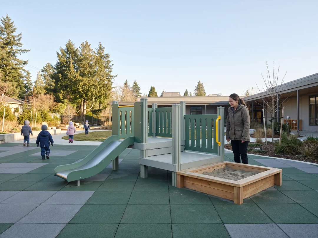 A daycare yard with a low-deck structure and a teacher beside it