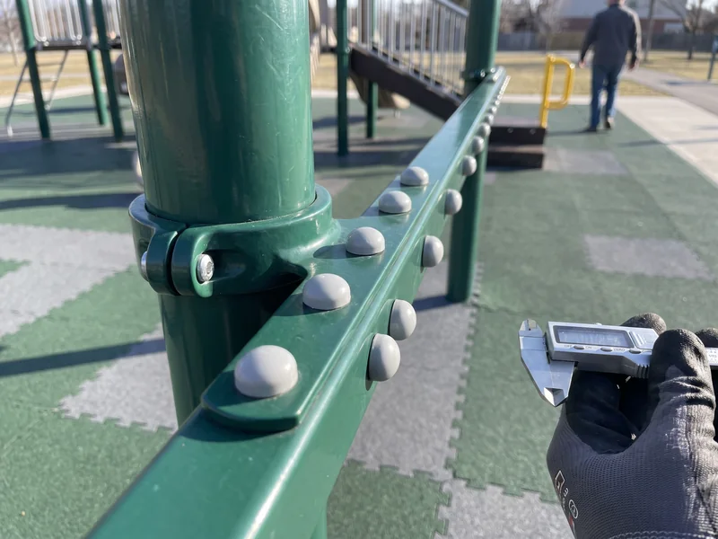 A row of capped fasteners on a clamp