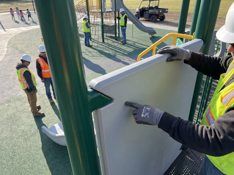 A gloved hand runs along a panel edge and a coated weld