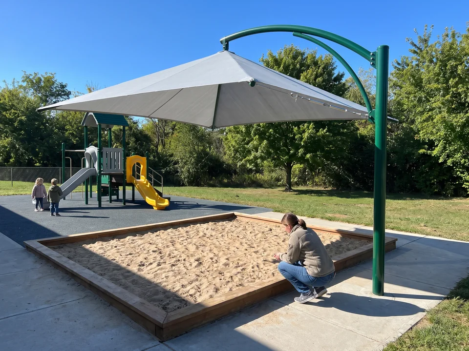Single-post cantilever shade reaching out over a sand area