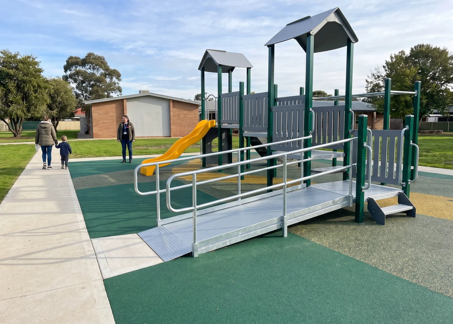An accessible route running from a paved path onto rubber surfacing and up a ramp to a transfer platform