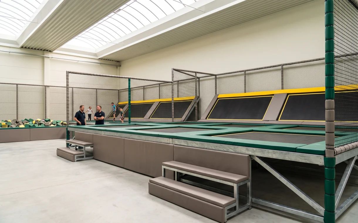 Raised trampoline court standing on the floor slab with step pads at the edge